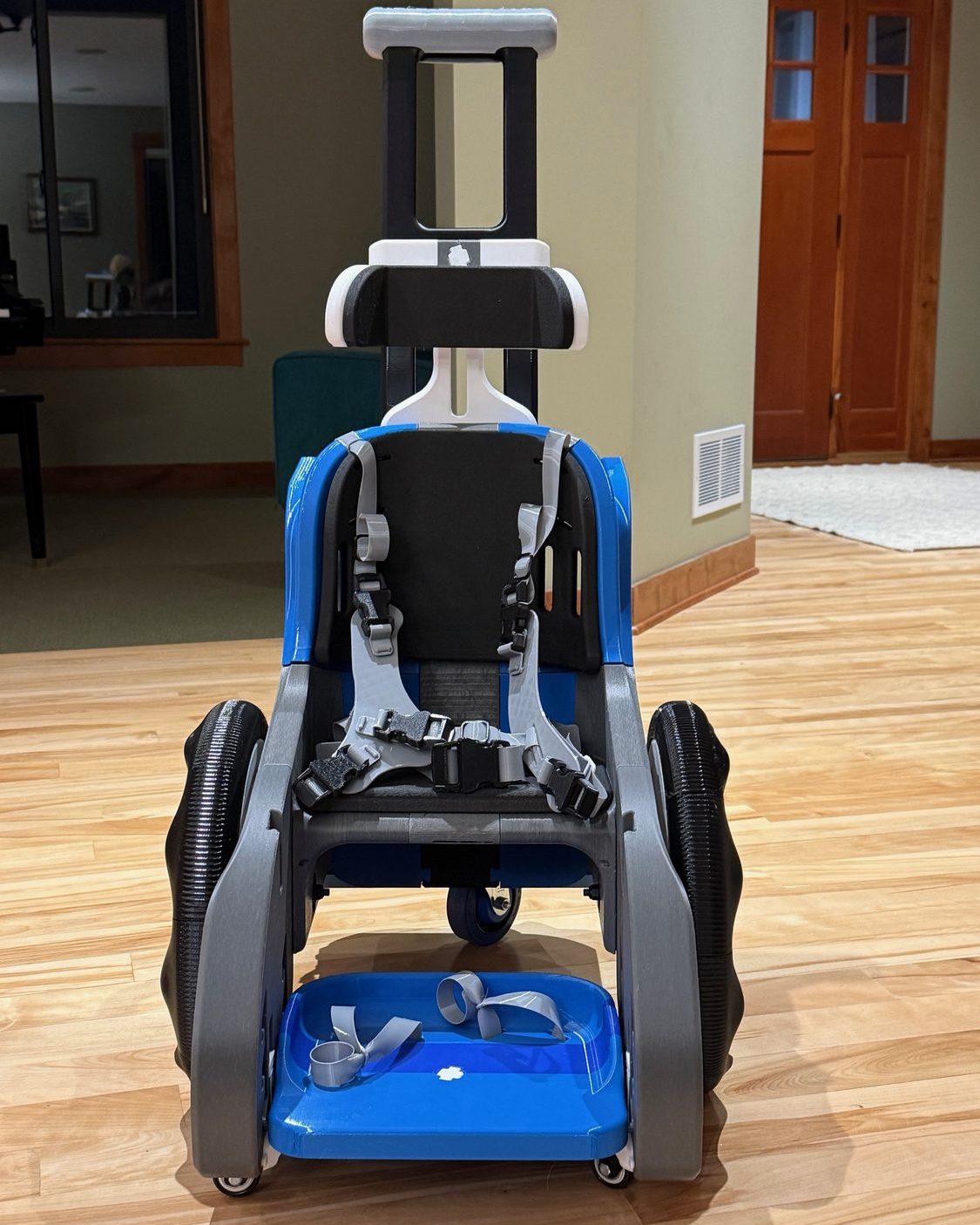 Toddler Mobility Trainer designed by MakeGood, blue chassis with carbon-fiber reinforced wheels and a harness seat, printed by Warner3D.